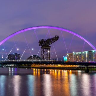 Night lights and the Clyde Arc Bridge at Glasgow City in Scotland over river.